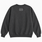 A dark heather gray crewneck sweatshirt shown from the back, featuring the text 'kind heart strong mind fierce soul' printed in small white letters on the upper back, set against a plain white background.