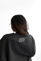Back close up view of Erin sweatshirt in shadow reading kind heart strong mind fierce soul