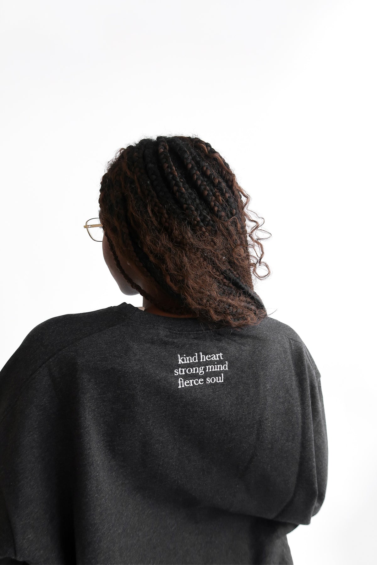 Back close up view of Erin sweatshirt in shadow reading kind heart strong mind fierce soul