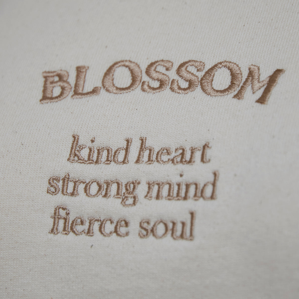 Erin sweatshirt in sand front embroidery saying Blossom with the slogan kind heart, strong mind, fierce soul