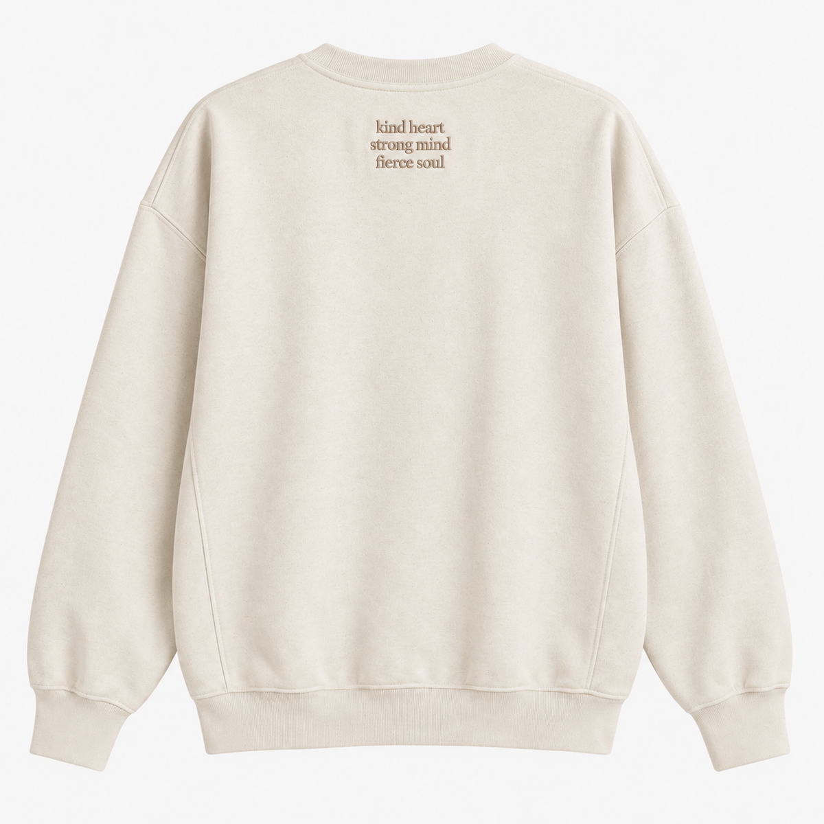 A cream-colored crewneck sweatshirt shown from the back, featuring the text 'kind heart strong mind fierce soul' printed in a small brown font on the upper back.