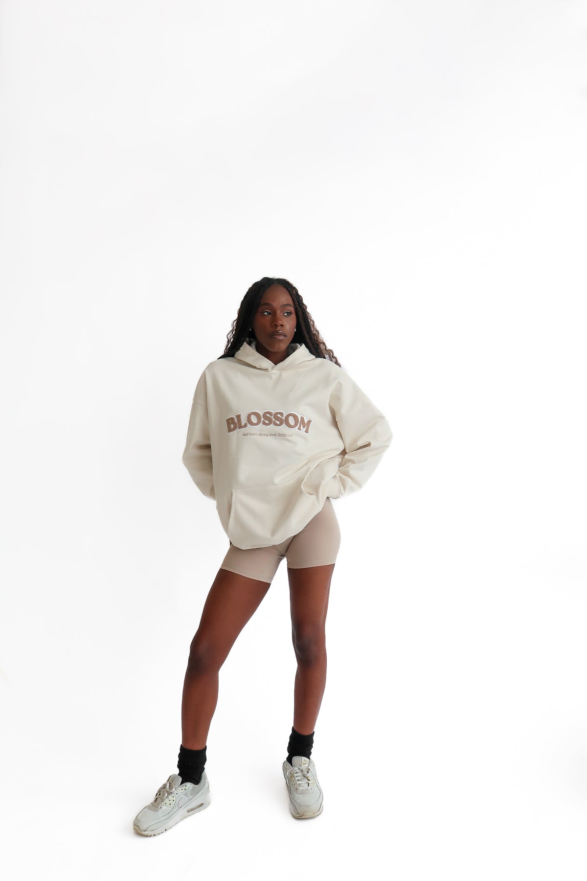 Woman posing full length wearing Blossom hoodie in colour sand