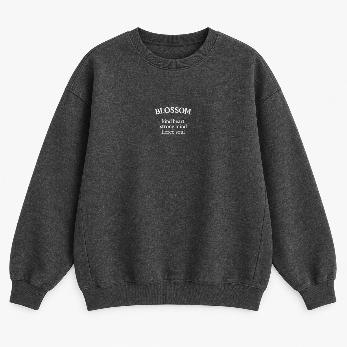 A dark gray heather crewneck sweatshirt with white text on the left chest reading 'BLOSSOM' and a smaller quote underneath that says 'kind heart, strong mind, fierce soul', displayed on a clean white background.