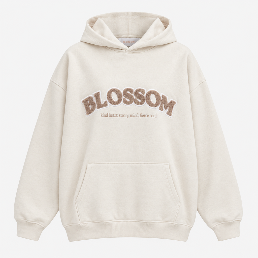 An off-white hooded sweatshirt with 'BLOSSOM' and a smaller quote printed in brown across the chest, displayed on a clean white background.