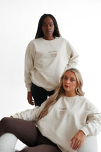 women wearing sand coloured Erin sweatshirts from blossom that say the slogan kind heart, strong mind, fierce soul. Meaningful garments.